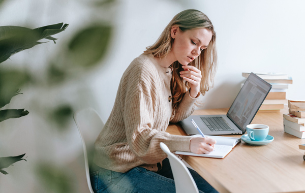 woman taking notes on table